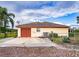 Detached garage with a red door and AC unit at 1937 Rifle Range Rd, Winter Haven, FL 33880