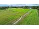 Aerial view showing a large green field with a dirt path at 1957 Rifle Range Rd, Winter Haven, FL 33880