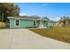 Newly built home with green exterior, landscaping, and a driveway at 221 Avenue P Nw, Winter Haven, FL 33881