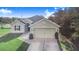 One-story house with a two-car garage and landscaped lawn at 230 Grouper Ct, Poinciana, FL 34759