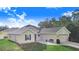 Tan house with a two-car garage and green lawn at 230 Grouper Ct, Poinciana, FL 34759