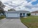 One-story home exterior with a two-car garage and landscaped lawn at 5838 Macaw Pl, Lakeland, FL 33809