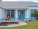 Home's exterior showcases a teal front door and neatly landscaped yard at 5838 Macaw Pl, Lakeland, FL 33809