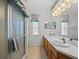 Well-lit bathroom with dual sinks, a shower, and a large mirror at 5838 Macaw Pl, Lakeland, FL 33809