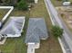 Aerial view showing a house with a gray roof and a single-car garage at 590 E Lemon Ave, Lake Alfred, FL 33850