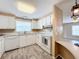 White kitchen with wood-look floors and stainless steel appliances at 6762 Brentwood Ne Dr, Winter Haven, FL 33881