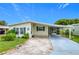 Single-wide manufactured home with covered carport and landscaped yard at 6762 Brentwood Ne Dr, Winter Haven, FL 33881