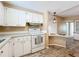 White kitchen with wood-look floors and stainless steel appliances at 6762 Brentwood Ne Dr, Winter Haven, FL 33881