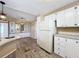 White kitchen with wood-look floors and stainless steel appliances at 6762 Brentwood Ne Dr, Winter Haven, FL 33881