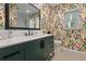 Modern bathroom with green vanity, patterned wallpaper and a large mirror at 1324 Mirror Nw Ter, Winter Haven, FL 33881