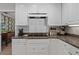 Updated kitchen with granite countertops and white cabinetry at 1324 Mirror Nw Ter, Winter Haven, FL 33881