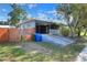 House exterior with a carport, wooden fence and driveway at 149 Avenue E Sw, Winter Haven, FL 33880