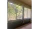 Sunroom featuring large windows and vertical blinds, overlooking trees at 1561 Vienna Square Dr, Winter Haven, FL 33884