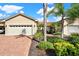 Tan house with two-car garage and landscaped yard at 1613 Linz Ct, Winter Haven, FL 33884