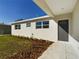 Newly built home with a white exterior, grey door, and landscaped lawn at 213 Rhea Cir, Lakeland, FL 33813