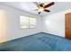Bright bedroom with ceiling fan and blue carpeting at 221 Dorothy St, Auburndale, FL 33823