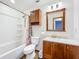 Updated bathroom with shower/tub combo and wood cabinets at 221 Dorothy St, Auburndale, FL 33823