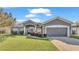 Gray house with two-car garage, landscaped lawn, and walkway at 2821 Sheldon St, Lakeland, FL 33813