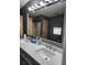 Double sink bathroom vanity with modern light fixture and large mirror at 312 Douglas Park Ave, Davenport, FL 33897