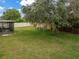 Spacious backyard with a large tree and screened patio at 364 Fish Hawk Dr, Winter Haven, FL 33884