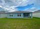 House exterior showcasing a covered patio and a spacious lawn at 535 Noble Ave, Davenport, FL 33837