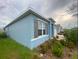 Side view of the house with gray shutters and well-manicured landscaping at 535 Noble Ave, Davenport, FL 33837