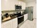 Modern kitchen with white cabinets, granite countertops, and stainless steel appliances at 535 Noble Ave, Davenport, FL 33837