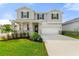 Two-story house with gray siding, stone accents, and a two-car garage at 9660 Westside Hills Dr, Davenport, FL 33896