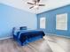 Spacious bedroom with light blue walls, wood-look floors, and ceiling fan at 1015 Joyce Rd, Lake Wales, FL 33853