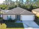 Single-story home with a two-car garage and landscaped yard at 1015 Joyce Rd, Lake Wales, FL 33853