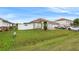 View of the house from the side, showcasing the yard and white fence at 1028 Dampierre Ct, Kissimmee, FL 34759