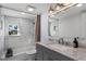 Modern bathroom with marble tile, grey vanity, and bathtub at 128 Caloosa Dr, Babson Park, FL 33827