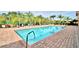 Inviting community pool surrounded by a brick patio and lounge chairs at 1644 Linz Ct, Winter Haven, FL 33884