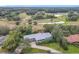 Aerial view of house and surrounding landscape, including a pond and golf course at 18 Coventry Dr, Haines City, FL 33844