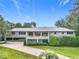 Single-story home with a large driveway and landscaped lawn at 18 Coventry Dr, Haines City, FL 33844
