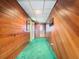 Long hallway with wood paneling and green carpeting at 18 Coventry Dr, Haines City, FL 33844