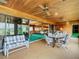 Covered patio with seating area and views to the game room at 18 Coventry Dr, Haines City, FL 33844