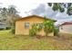 Side view of the house, showcasing its yellow brick exterior and landscaping at 1807 4Th Nw St, Winter Haven, FL 33881