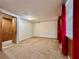 Bright bedroom with wood paneling, red curtains, and neutral carpeting at 217 W Lake Ina Dr, Winter Haven, FL 33884