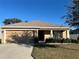 Front view of a single-story house with a two-car garage and well-maintained lawn at 222 Cattail Way, Lake Alfred, FL 33850