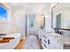 Bright bathroom boasts double vanity, free-standing tub, and wood-look floors at 2997 Sequoyah Dr, Haines City, FL 33844