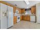 Kitchen with light wood cabinets, white appliances, and tile flooring at 3309 Raleigh Dr, Winter Haven, FL 33884