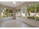 Sunroom with tiled floor, sliding glass doors and lush greenery views at 3309 Raleigh Dr, Winter Haven, FL 33884