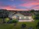 Backyard view of house at sunset with screened patio at 3604 Blackmoor Ln, Lake Wales, FL 33859