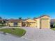 Front view of a charming yellow house with a large driveway and three-car garage at 3604 Blackmoor Ln, Lake Wales, FL 33859