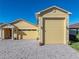 Front view of a charming yellow house with a large driveway and three-car garage at 3604 Blackmoor Ln, Lake Wales, FL 33859