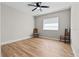 Bright bedroom with ceiling fan, wood-look floors, and two chairs at 501 Arneson Ave, Auburndale, FL 33823