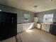 Bright kitchen with white cabinets and a black fridge at 102 Luna Rd, Auburndale, FL 33823