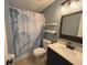 Clean bathroom with a shower/tub combo and floating shelves at 1082 Sunshine Sw Way, Winter Haven, FL 33880