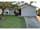 Cute one-story house with gray siding, a blue door, and a well-manicured lawn at 1082 Sunshine Sw Way, Winter Haven, FL 33880